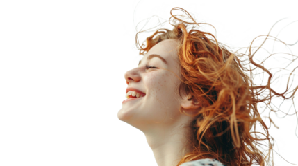 Carefree young woman with vibrant red hair laughing in the wind