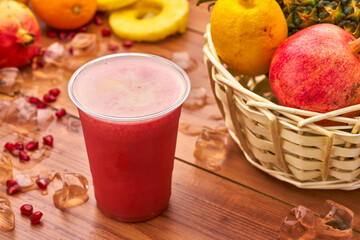 Red Fruit Smoothie with Pomegranate, Pineapple, and Lemon in glass side view of delicious refreshment