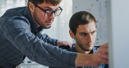 Team adult male engineer collaborate on robotic hand project using AI code solutions machine learning at tech workspace. Artificial intelligence interface, collaboration support prototype development.