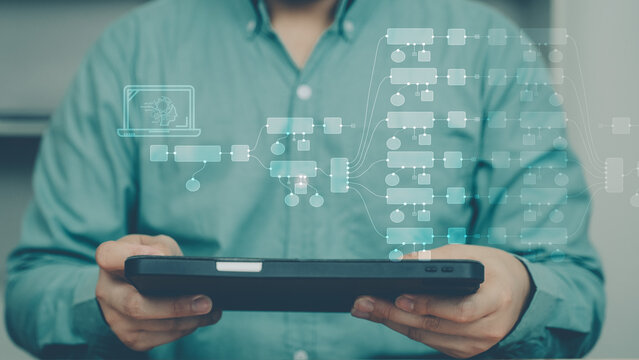 Businessman using tablet with holographic workflow automation interface. Concept of AI automation, N8N style flow, digital transformation, and automatic process management.