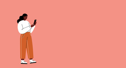 Young woman using a smartphone for online communication or browsing social media on a plain coral background with copy space.