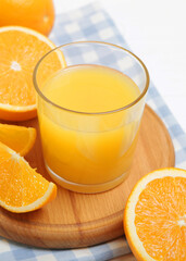 Orange juice in a glass, oranges and orange slices on the table.. Vertical photo format