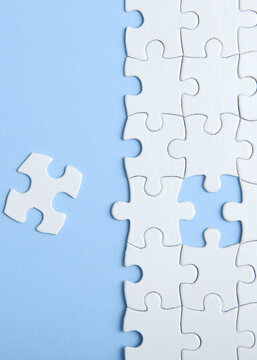 White puzzle on a colored background top view.. Vertical photo format
