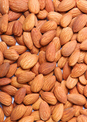 Whole almonds isolated on white background close-up. Vertical photo format