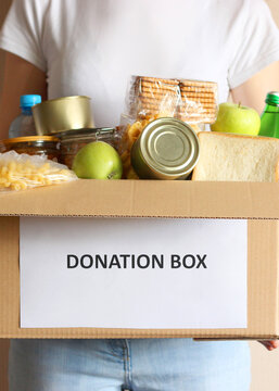 girl holding a box with donations close-up. Vertical photo format