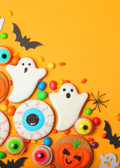Halloween sweets on colored background close up top view with place for text. Vertical photo format