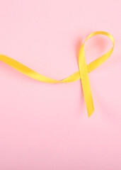 yellow ribbon symbolizing cancer in children top view. Vertical photo format