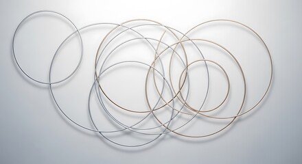 Elegant intertwining metal circles on a soft gradient backdrop creating a balanced and minimalist artistic composition