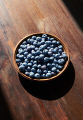 Blueberries in wooden bowl on a wooden