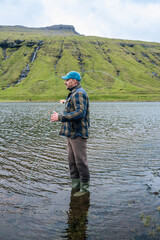 Man Fly Fishing in Mountain Lake on the Faroe Islands