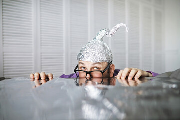Bearded funny man in a cap of aluminum foil. Concept art phobias.Conspiracy theory. Conspiracy....