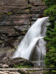 Fototapeta premium A varied trail where waterfalls highlight the changing beauty of mountains, lakes and forests in Waterton lake national park, Alberta, Canada