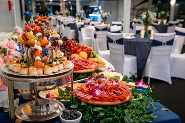 Chic buffet at a banquet. Delicious spread of gourmet foods arranged beautifully for a banquet, featuring colorful fruits and savory meats.