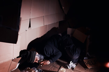 A homeless bearded man sits on boxes on the street and asks for help. Need a homeless person asks...