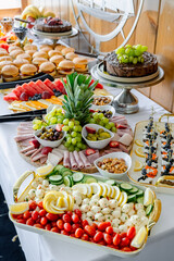 Tasty food spread for gatherings. A vibrant display of fruits, meats, and sweets on a table for a social gathering.