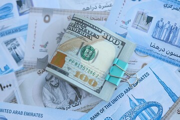 United Arab Emirates dirham currency money bills and bunch of us dollar banknotes. The concept of economics and currency exchange