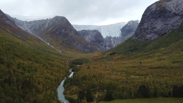 Cinematic drone stock footage clip of a valley glacier and river in Jostedalsbreen National Park, Norway. Landscape orientation. Background video.