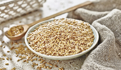 Złoty len w miseczce z drewnianą łyżeczką obok