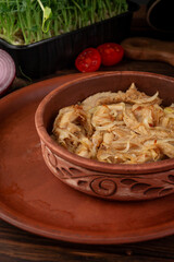 Tender braised tripe cooked with onion and spices served in rustic clay bowl on wooden table authentic homemade dish