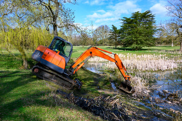 digger clearing vegetation from a pond © Bruce