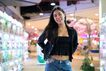 Happy young woman playing arcade video games indoors