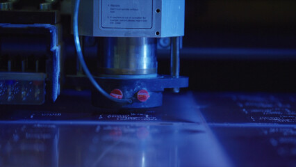 Close up of an industrial laser engraving machine precisely etching intricate designs onto a metal...