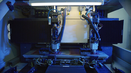 Located within a bustling factory, a sophisticated laser cutting machine processes materials with remarkable precision and efficiency, all while being illuminated by vibrant blue light