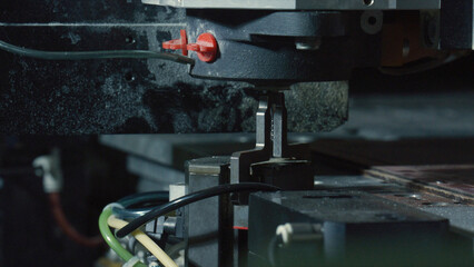 Close up of a laser cutting machine precisely processing material in a factory setting, showcasing the advanced technology and precision of modern manufacturing processes