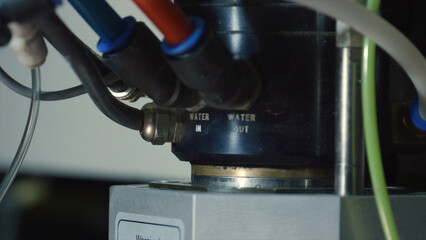 Close up view of a water pump with clearly marked water inlet and outlet pipes, highlighting the essential components of a water cooling system