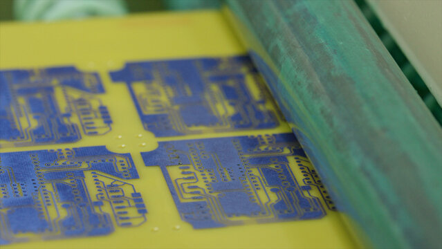 Automated machine applying solder paste on a printed circuit board in a modern electronics factory, highlighting advanced manufacturing technology and precision engineering