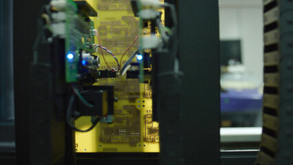 Close up of an electronic device analyzing a circuit board, emitting a blue light, with laboratory equipment in the background, showcasing technological advancement and innovation