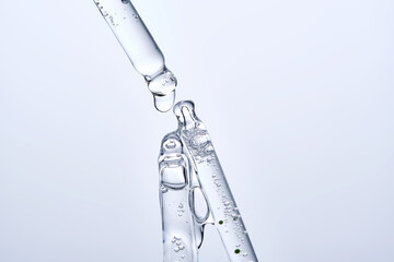 Three different face serum pipettes on a neutral background.