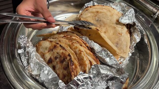 Tandoori roti and butter nan served in aluminium foil in an Indian wedding