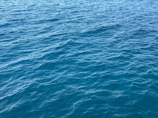 Calm sea water with gentle waves and sparkling sunlight reflections. High-resolution ocean texture, perfect for travel, nature, and background design.