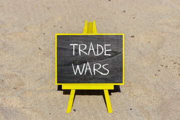 Trade wars symbol. Concept word Trade wars on beautiful black blackboard. Beautiful sand beach background. Black blackboard. Business trade wars concept. Copy space.
