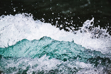 Closeup shot of water crashing up against a boulder