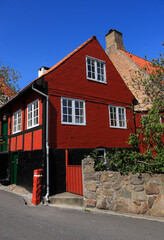 Denmark, Bornholm Island, Gudhjem. Typical street and old wood and brick red house facade.