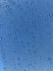 sparkling water drops on glass, drops of water, sparkles, water, dark circles around water. 