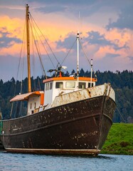 Naklejka premium Old fishing boat at sunset