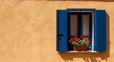 A charming blue window with open shutters and a vibrant red geranium flower pot against a rustic yellow ochre stucco wall, evoking Mediterranean charm