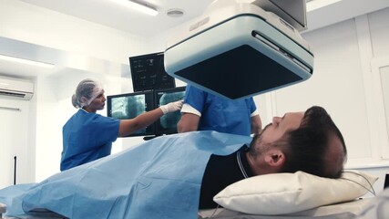 Medical professionals in surgical attire are performing an angiograph procedure in a modern hospital setting, showcasing advanced technology and teamwork in patient care and diagnostics