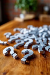 Scattered silver question marks on wooden table symbolizing curiosity and inquiry