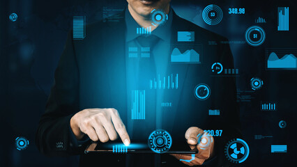 A business professional engages with a tablet, exploring complex data visualizations and infographics, emphasizing technology role in modern analysis and decision-making. Xenic