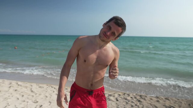 Man Shaking Water Out of Ears After Swimming at the Beach