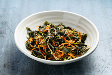 Wakame Seaweed Salad with carrot and zucchini in a bowl. Healthy food.