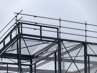 Detailed view of steel scaffolding framework with safety mesh on construction project