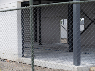 Obraz premium Chain-link fence foreground with scaffolding and building construction visible beyond barrier