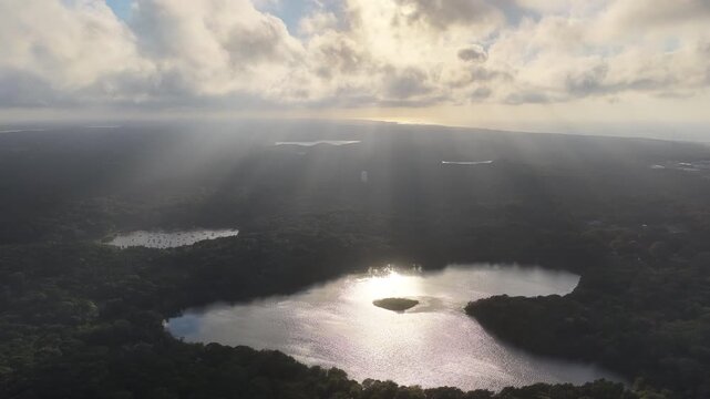 Beams of sunlight fall through low clouds illuminating Pilgrim Lake in Orleans on Cape Cod. This scenic Massachusetts peninsula harbors many ponds and lakes left over from the last glacial period.