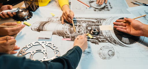 A dynamic group collaboration captures hands engaged in drawing details of a jet engine, showcasing...