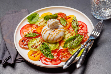 Fresh burrata served on slices of colorful tomatoes